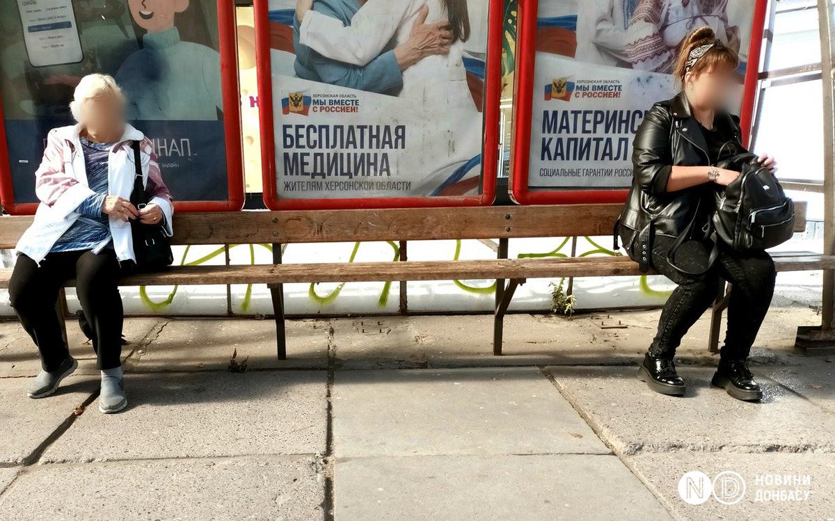 Жители оккупированного Херсона ждут автобус на остановке с пророссийскими плакатами. Сентябрь 2022. Фото: Виктория Рощина / Новости Донбасса