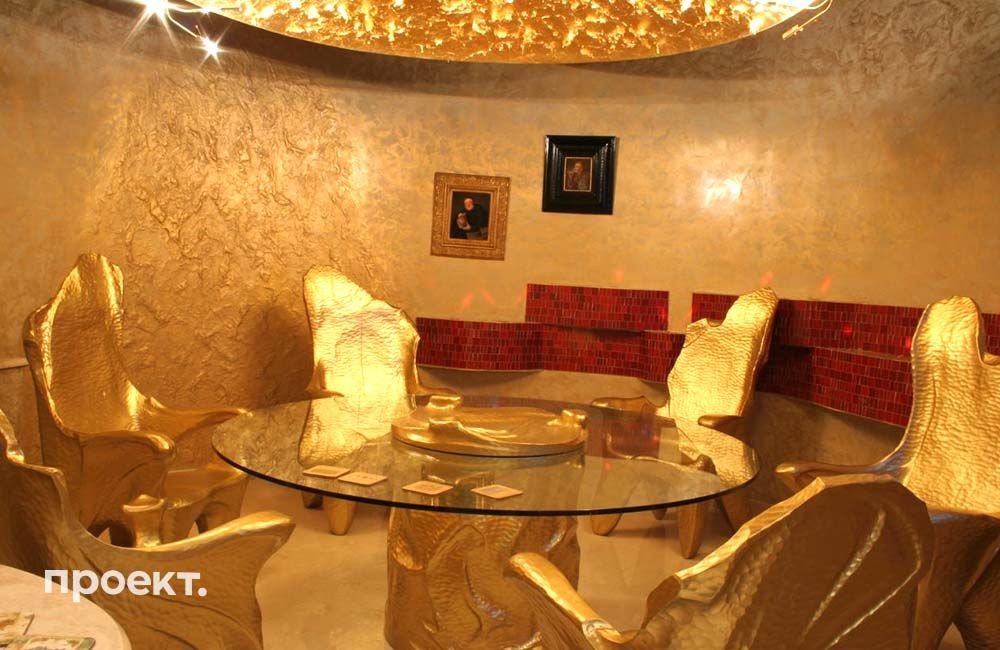 Это место строители называют «погребок». Здесь Путин и гости отдыхают на позолоченных стульях, а над ними нависает люстра в виде шара. С нее свисает сусальное золото — это сделано специально, чтобы можно было сорвать лепесток. Фото: proekt.media